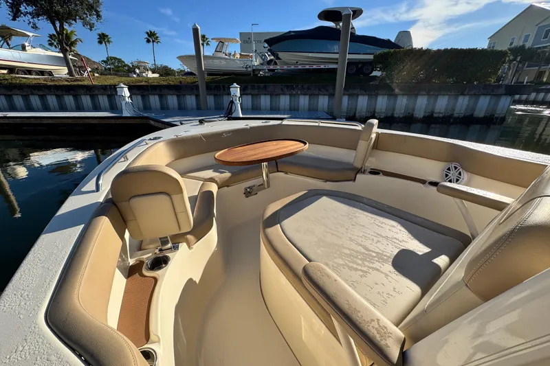 Slide: The Image of 2022 Scout 215 XSF boat interior with seating and table, docked near water. - 20