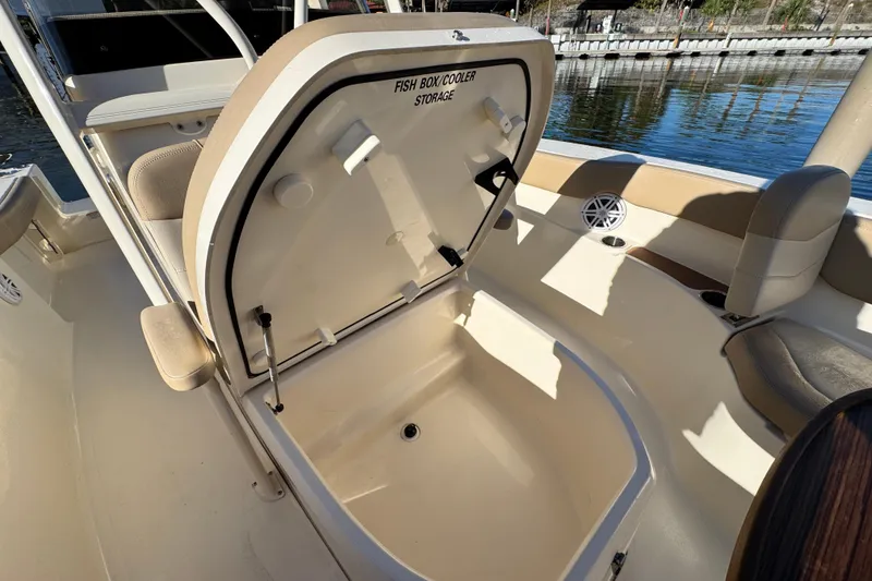 Slide: The Image of 2022 Scout 215 XSF boat with open fish box cooler storage. - 22