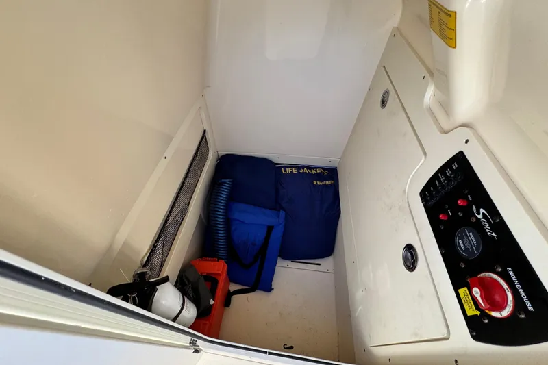 Slide: The Image of 2022 Scout 215 XSF storage compartment with life jackets and control panel. - 24