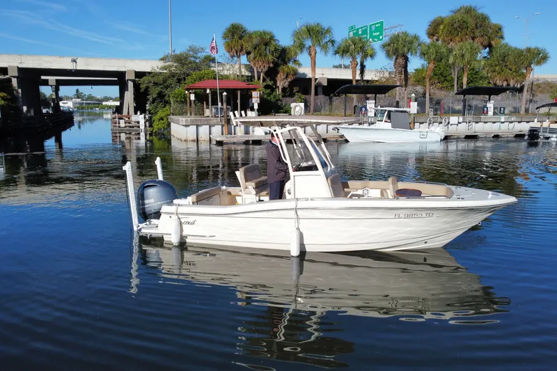 Slide: The Image of 2022 Scout 215 XSF boat docked in a scenic marina with palm trees. - 4