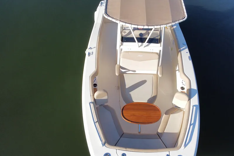 Slide: The Image of 2022 Scout 215 XSF boat with beige interior and wooden table, aerial view. - 7