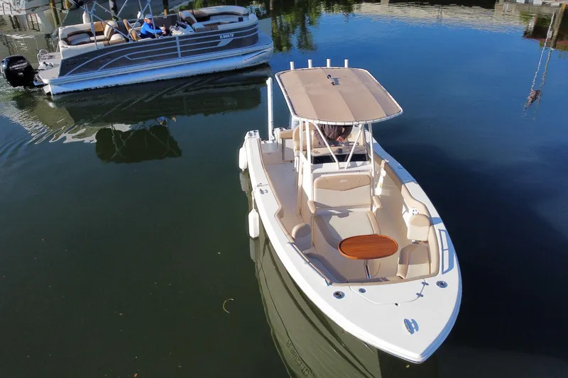 Slide: The Image of 2022 Scout 215 XSF boat on calm water, featuring a sleek design and spacious seating. - 8