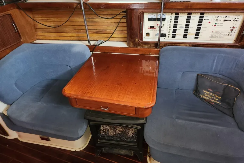 Slide: The Image of Interior of 1993 Catalina Morgan 381 sailboat with blue seating and wooden table. - 11