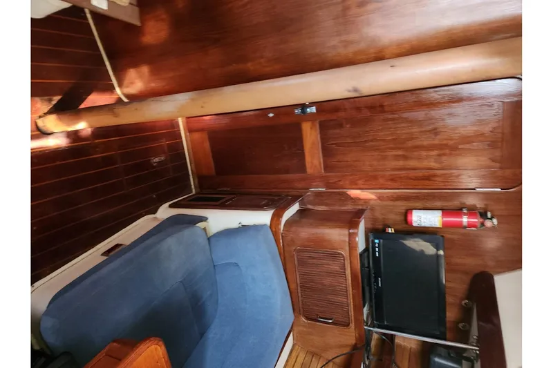 Slide: The Image of Interior of 1993 Catalina Morgan 381 sailboat with wood paneling and blue seating. - 12