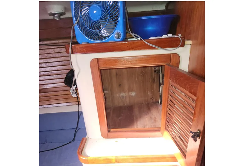 Slide: The Image of Interior of 1993 Catalina Morgan 381 with open wooden cabinet and blue fan. - 16
