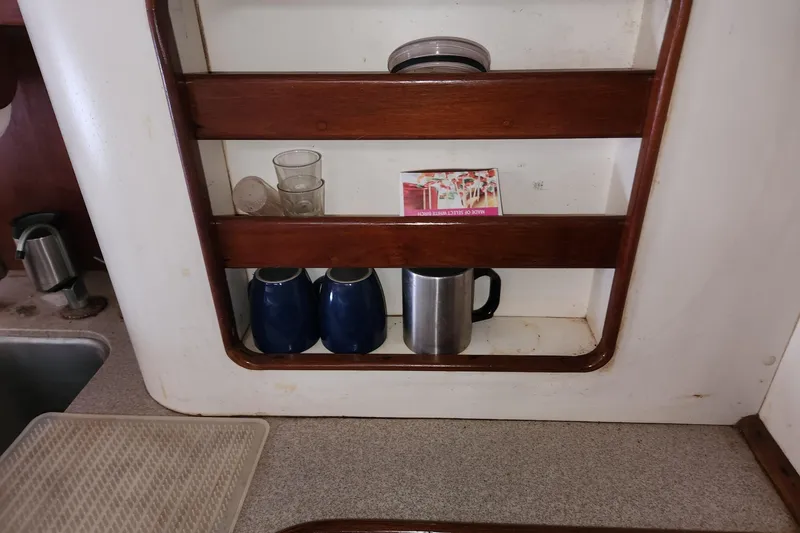 Slide: The Image of Kitchen shelf on 1993 Catalina Morgan 381 with mugs, glasses, and a drink mix box. - 19
