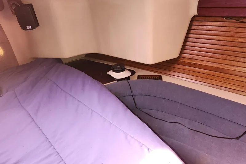 Slide: The Image of Interior of 1993 Catalina Morgan 381 sailboat with wooden paneling and cozy bedding. - 21