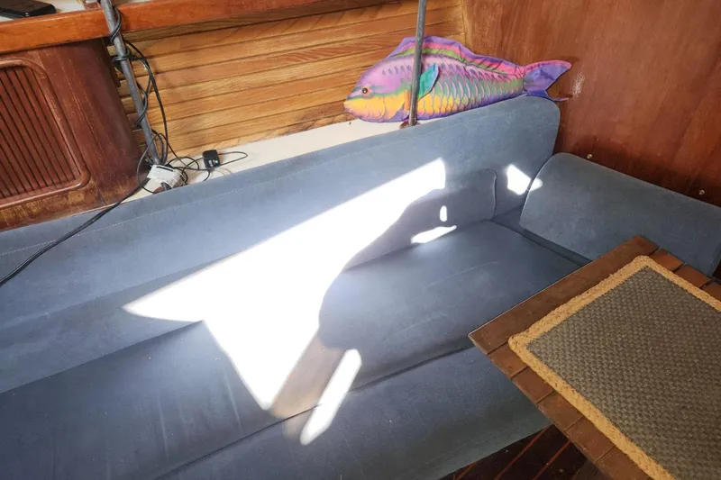 Slide: The Image of Interior of 1993 Catalina Morgan 381 sailboat with blue sofa and colorful fish decor. - 6