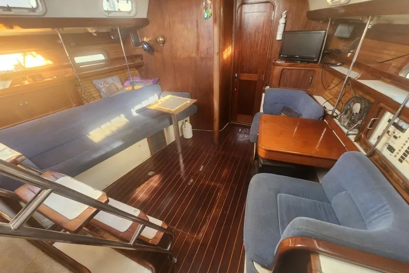 Slide: The Image of Interior of 1993 Catalina Morgan 381 sailboat with wooden furnishings and blue seating. - 8