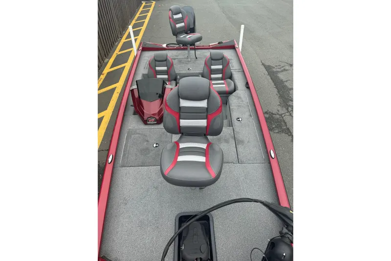 Slide: The Image of 2021 Ranger RT178 boat interior with gray and red seating, parked on pavement. - 4