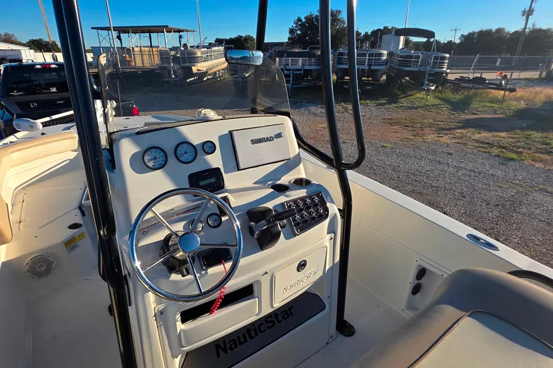 Slide: The Image of 2017 NauticStar 231 Angler boat dashboard with steering wheel and controls. - 10