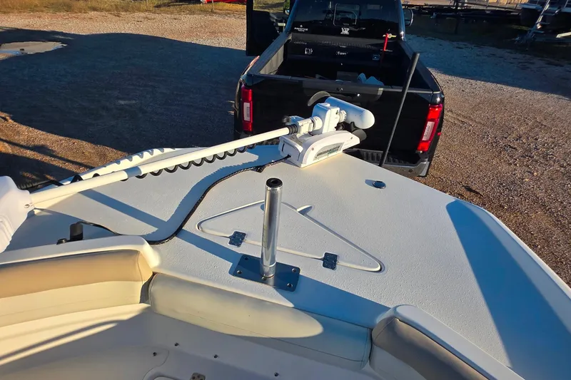 Slide: The Image of 2017 NauticStar 231 Angler boat with trolling motor, parked near a black truck. - 18