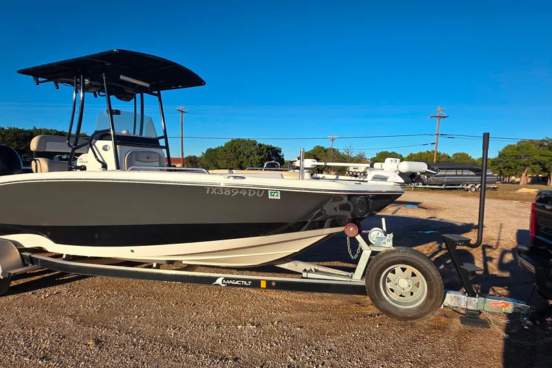 Slide: The Image of 2017 NauticStar 231 Angler boat on trailer under clear blue sky. - 2