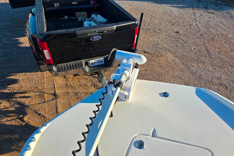 Slide: The Image of 2017 NauticStar 231 Angler boat with trolling motor near black Ford truck. - 25