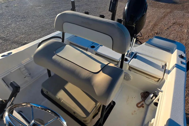 Slide: The Image of 2017 NauticStar 231 Angler boat interior with seating and steering wheel. - 27