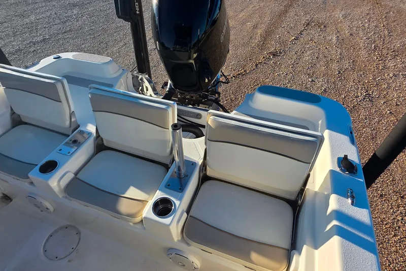 Slide: The Image of 2017 NauticStar 231 Angler boat seats and motor, featuring cup holders and rod holders. - 9