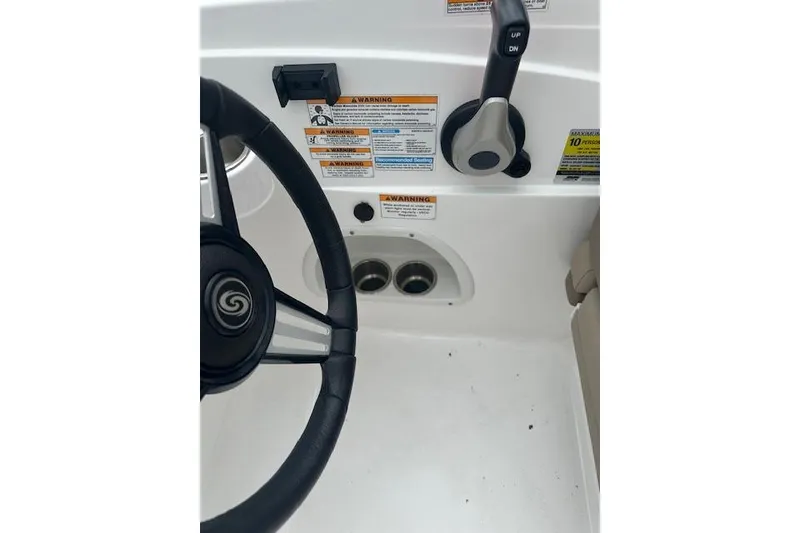 Slide: The Image of 2023 Hurricane SunDeck Sport 205 OB steering wheel and controls with warning labels. - 5