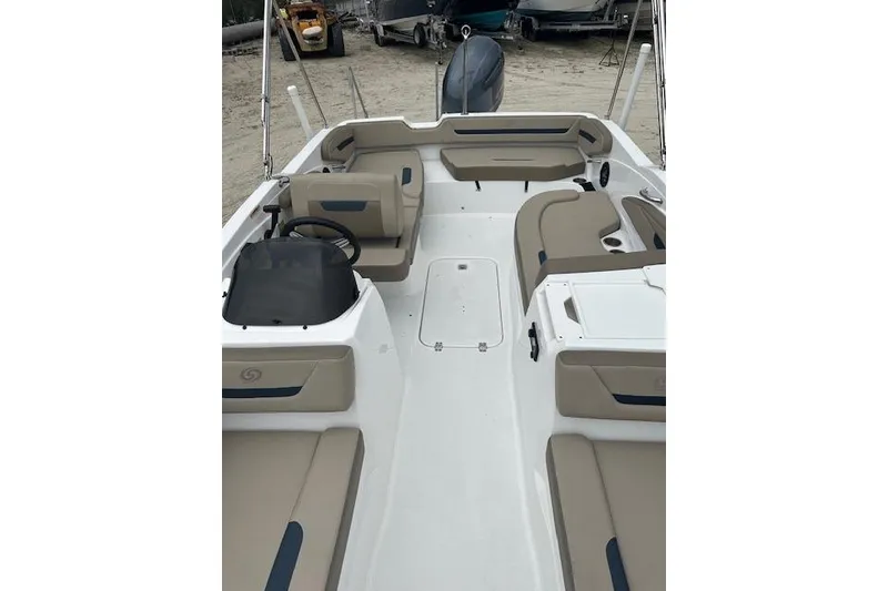 Slide: The Image of 2023 Hurricane SunDeck Sport 205 OB boat interior with beige seating and steering console. - 6