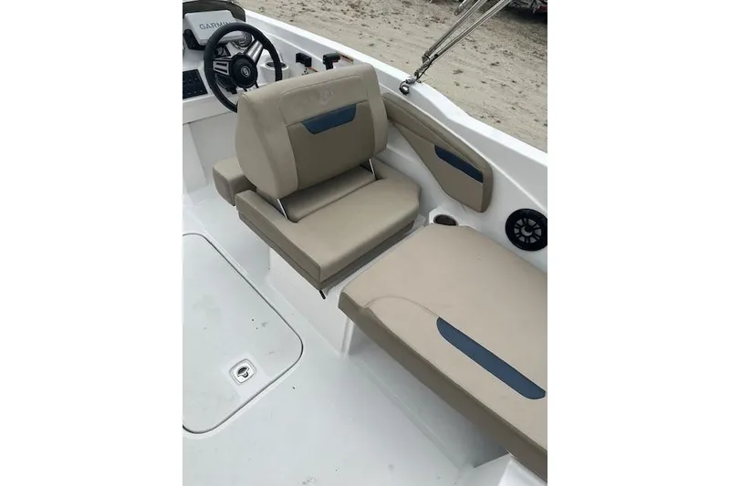 Slide: The Image of 2023 Hurricane SunDeck Sport 205 OB boat interior with beige seating and steering wheel. - 9