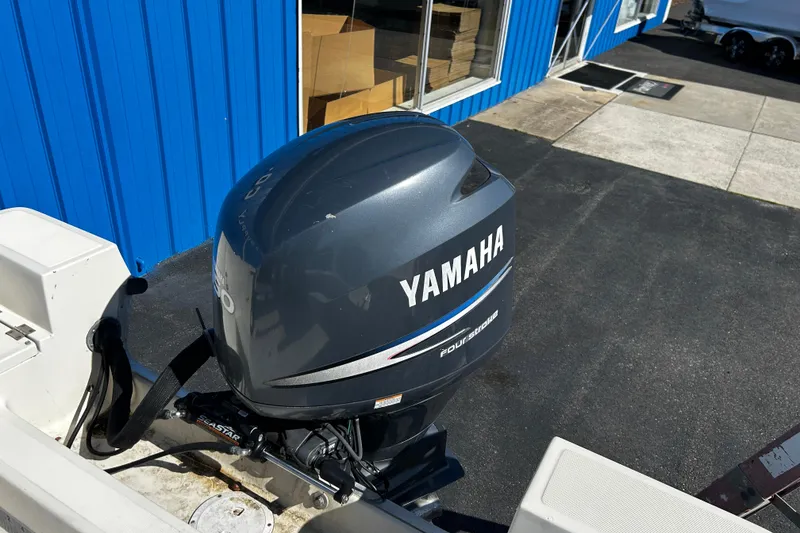 Slide: The Image of 1994 Stratos 1850 Center Console with Yamaha outboard motor, parked near blue building. - 21