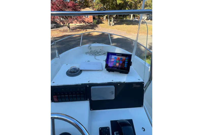 Slide: The Image of 1994 Stratos 1850 Center Console boat with Yamaha motor, parked near blue building. - 13