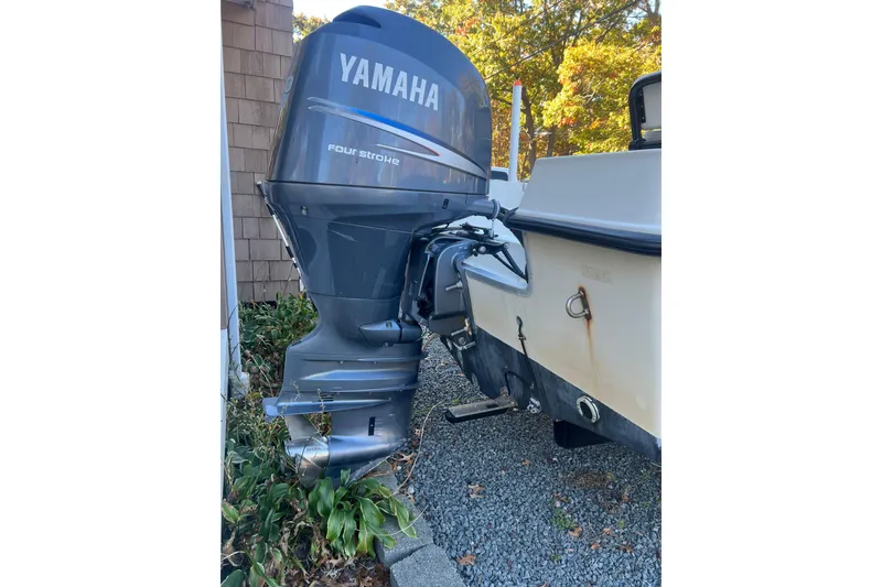 Slide: The Image of 1994 Stratos 1850 Center Console with Yamaha outboard motor, parked near a house. - 19