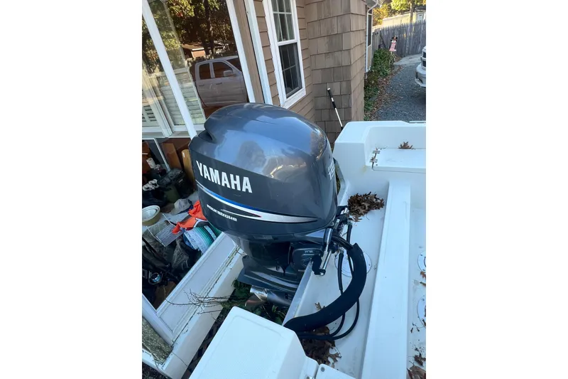 Slide: The Image of 1994 Stratos 1850 Center Console with Yamaha outboard motor, parked near a house. - 16
