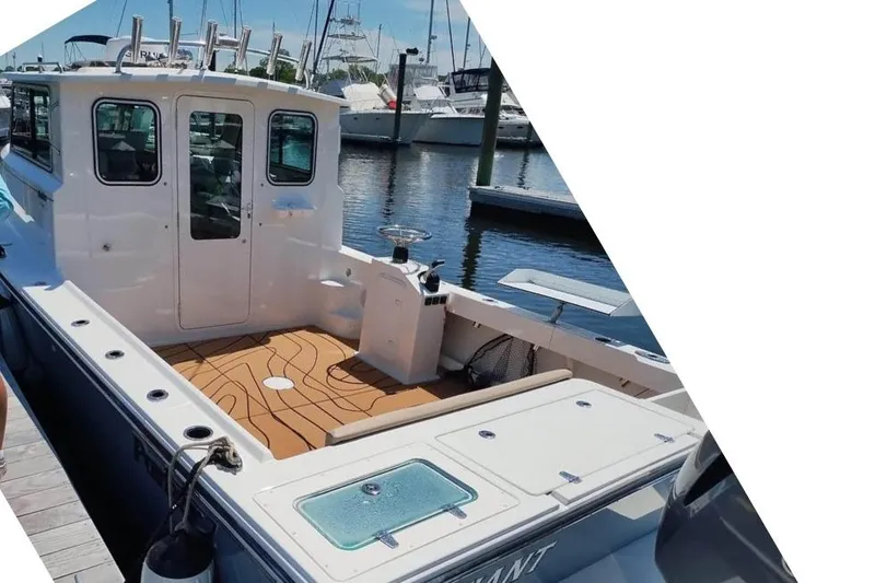 Slide: The Image of 2019 Parker 2520 XL Sport Cabin boat docked at marina, featuring spacious deck and cabin. - 3