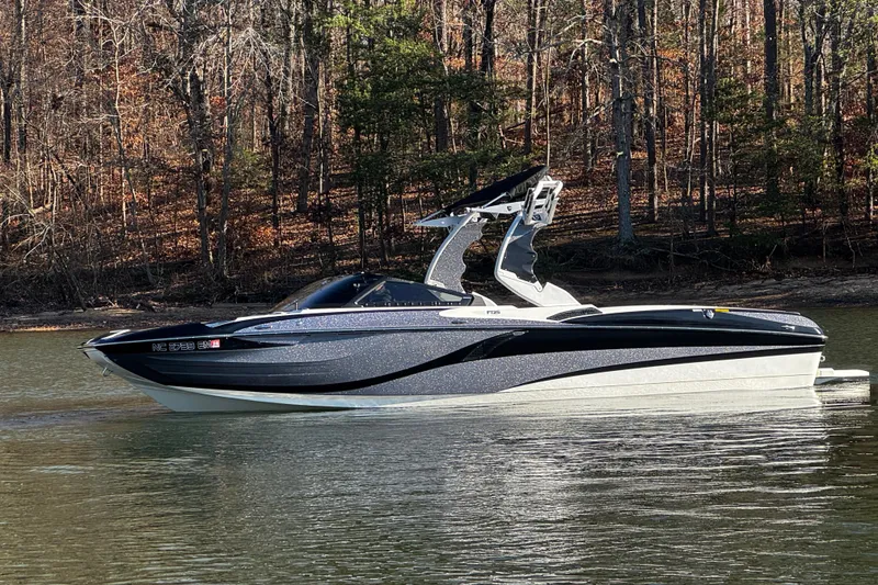 Slide: The Image of 2019 Centurion Fi25 boat on a calm lake with forested background. - 10