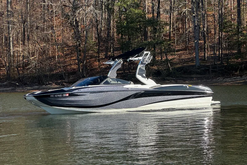 Slide: The Image of 2019 Centurion Fi25 boat on a calm lake with forested background. - 11