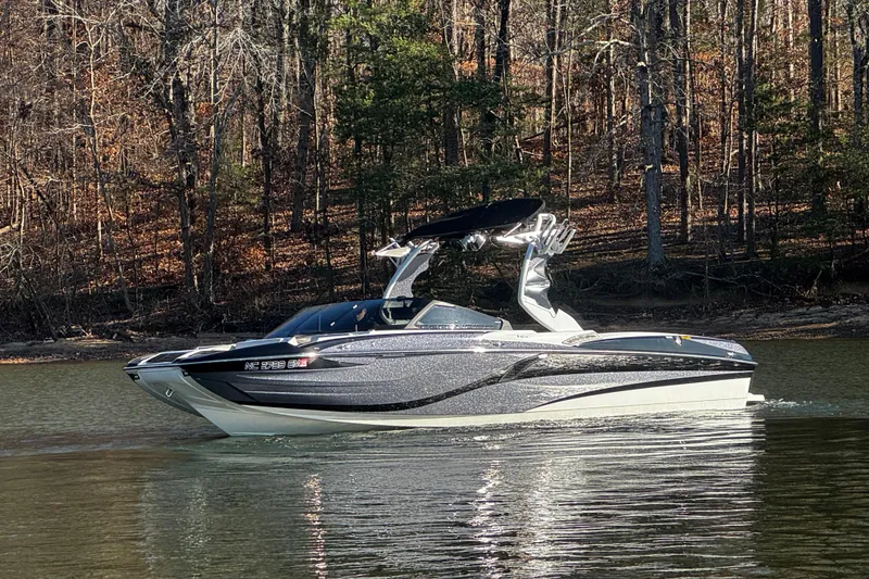 Slide: The Image of 2019 Centurion Fi25 boat cruising on a calm lake with forested background. - 13