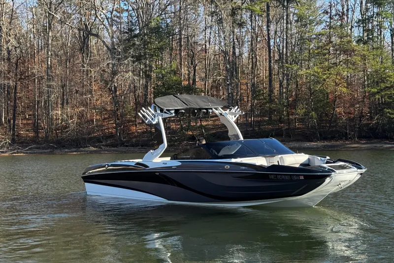 Slide: The Image of 2019 Centurion Fi25 boat on a calm lake with forest backdrop. - 2