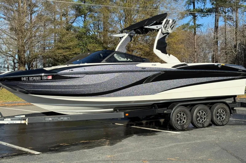 Slide: The Image of 2019 Centurion Fi25 boat on trailer, parked outdoors, showcasing sleek design and modern features. - 24