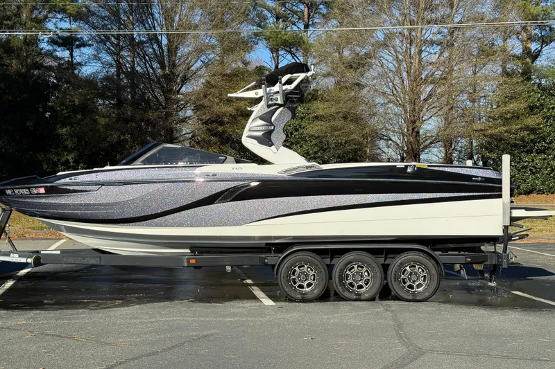 Slide: The Image of 2019 Centurion Fi25 boat on trailer, parked outdoors, showcasing sleek design and modern features. - 25
