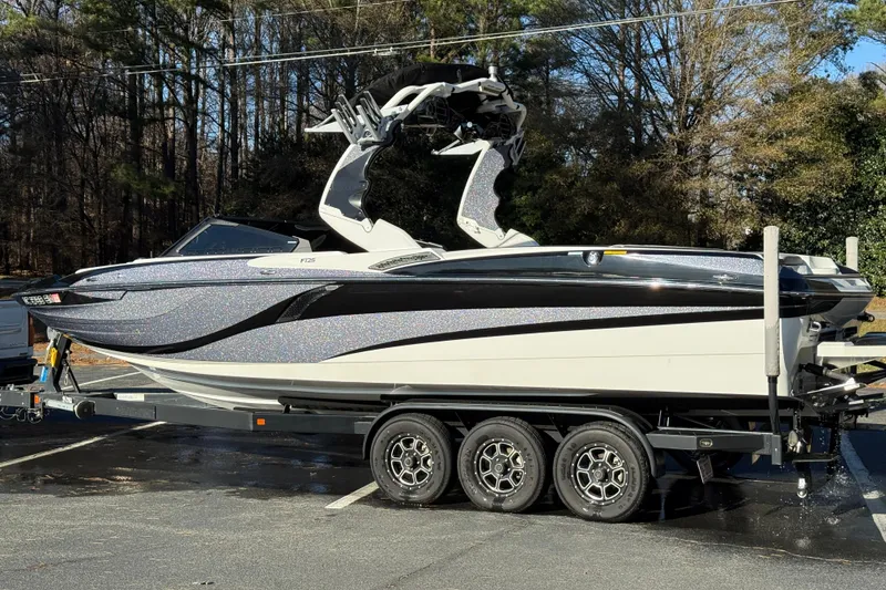 Slide: The Image of 2019 Centurion Fi25 boat on trailer, parked outdoors, surrounded by trees. - 26
