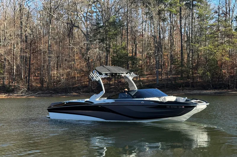 Slide: The Image of 2019 Centurion Fi25 boat on a calm lake with forest backdrop. - 3