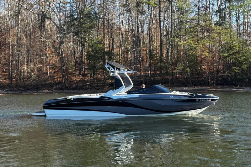 Slide: The Image of 2019 Centurion Fi25 boat cruising on a calm lake with forested background. - 4