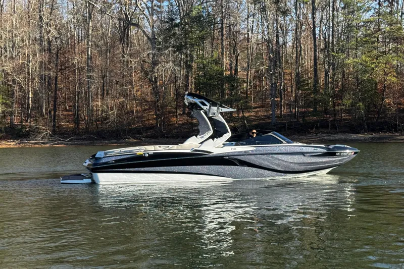 Slide: The Image of 2019 Centurion Fi25 boat on a calm lake with forested background. - 5