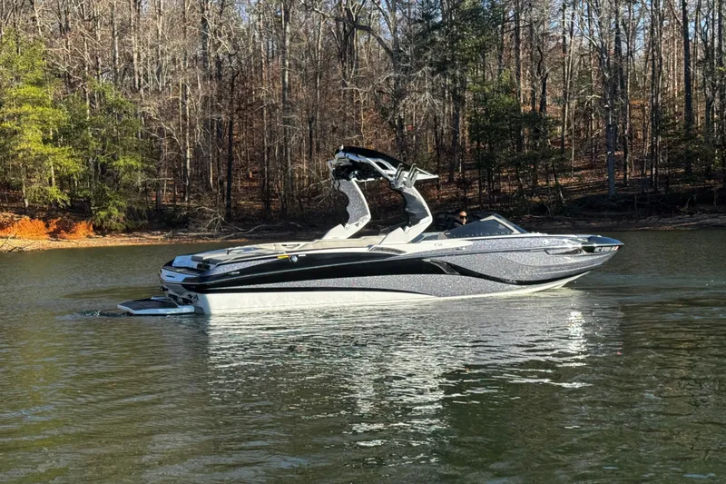 Slide: The Image of 2019 Centurion Fi25 boat on a calm lake with forested background. - 6