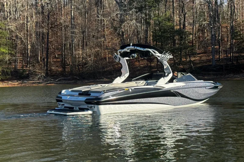 Slide: The Image of 2019 Centurion Fi25 boat on a calm lake with forest backdrop. - 7