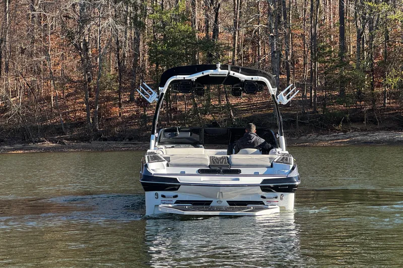 Slide: The Image of 2019 Centurion Fi25 boat on a calm lake, surrounded by trees. - 8