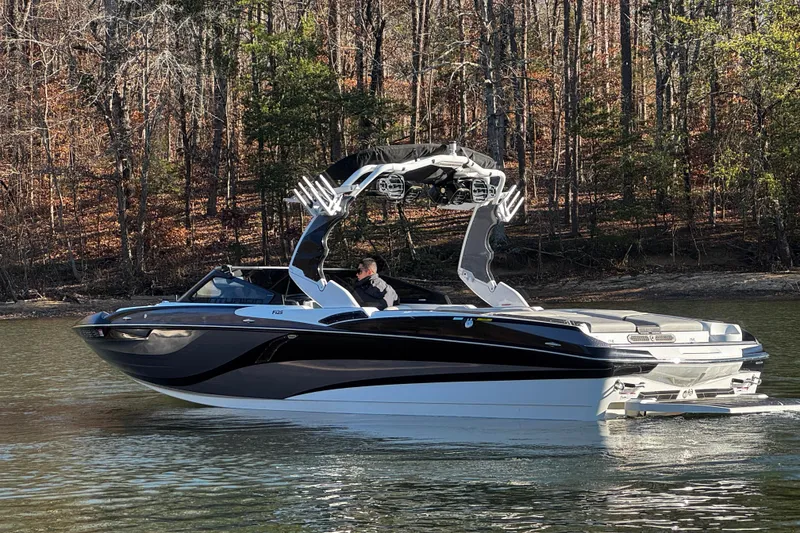 Slide: The Image of 2019 Centurion Fi25 boat on a calm lake with forested background. - 9