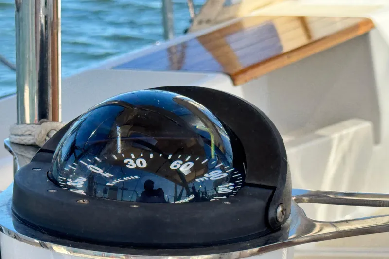 Slide: The Image of Compass on Tartan 4000 sailboat, 2013 model, reflecting blue sky and water. - 46