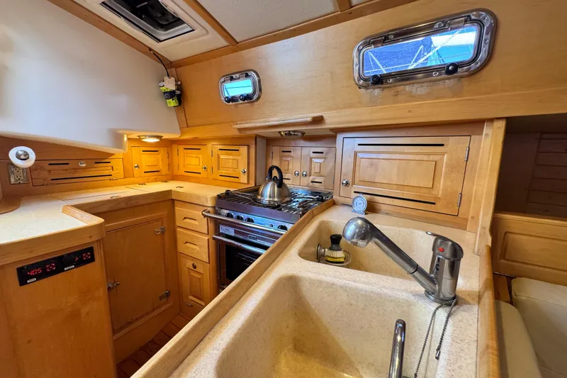 Slide: The Image of Cozy Tartan 4000 yacht kitchen with wooden cabinets, stove, and sink, 2013 model. - 58