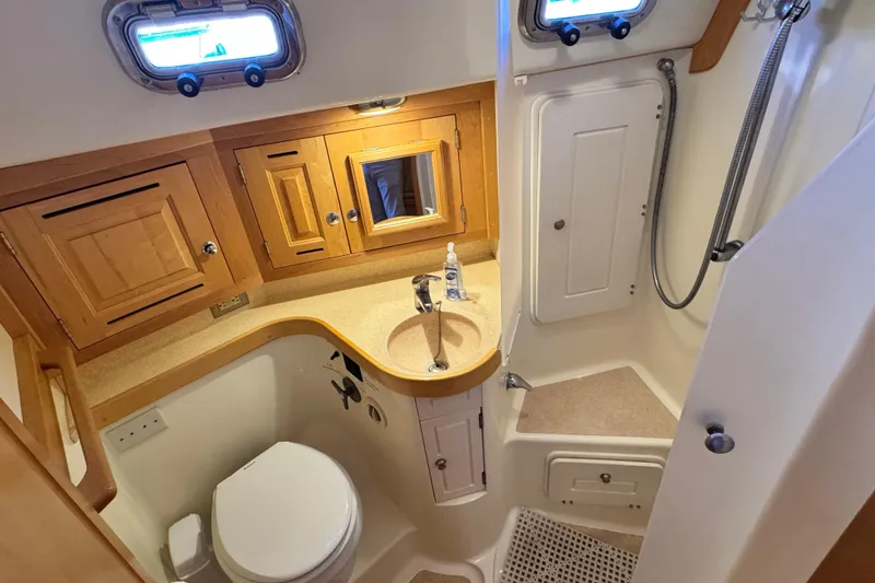 Slide: The Image of 2013 Tartan 4000 yacht bathroom with wooden cabinets, sink, and shower area. - 67