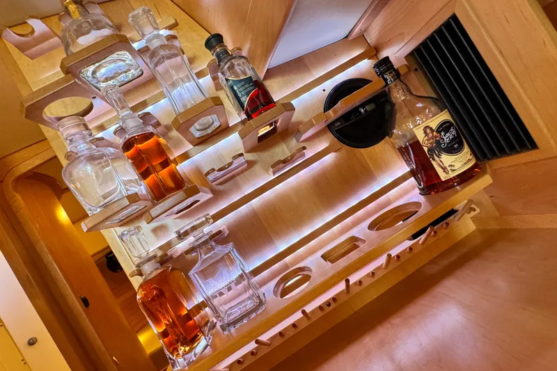 Slide: The Image of Luxurious wooden bar setup in a 2013 Tartan 4000 yacht, featuring various liquor bottles. - 69