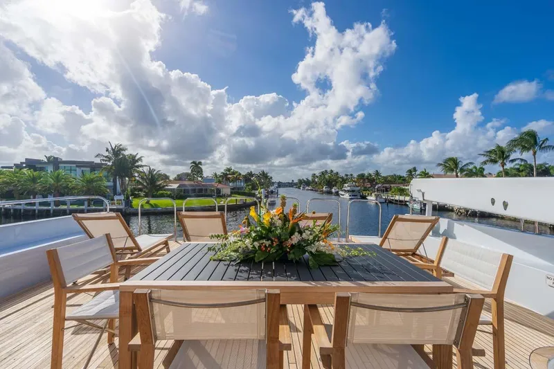 Slide: The Image of Luxurious 1995 Christensen Tri-Deck yacht deck with elegant outdoor dining setup, scenic waterfront view. - 31