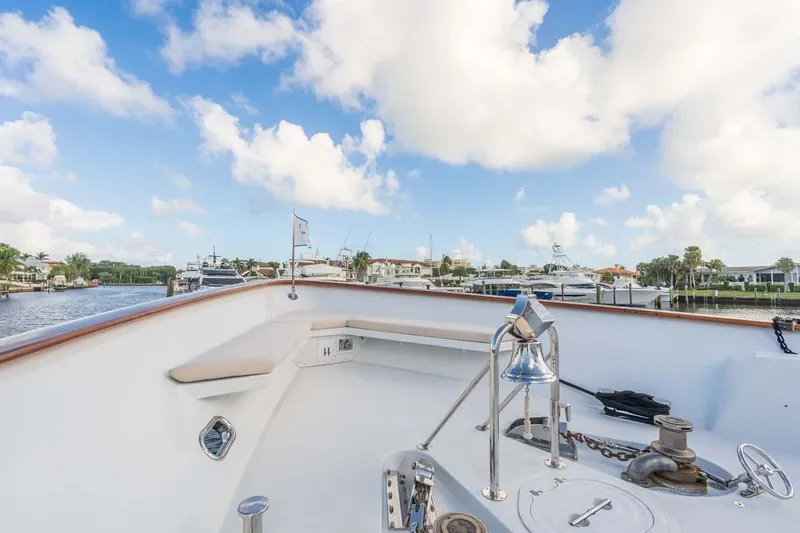 Slide: The Image of Christensen Tri-Deck 1995 yacht deck with bell, docked in a scenic marina. - 40
