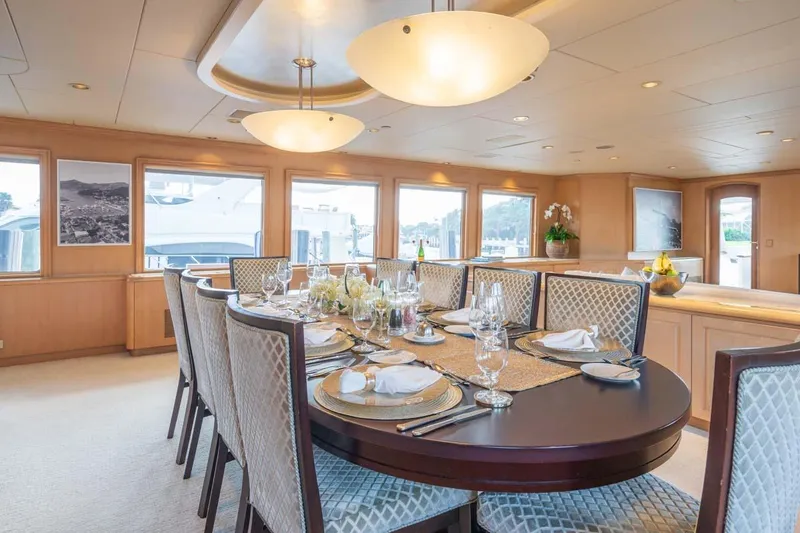 Slide: The Image of Luxurious dining area on a 1995 Christensen Tri-Deck yacht, elegantly set table with panoramic views. - 7