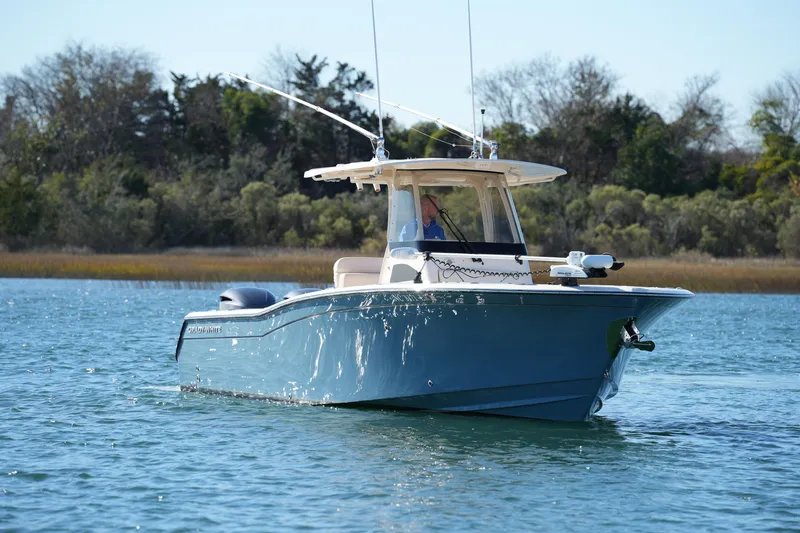 Slide: The Image of 2021 Grady-White Canyon 271 boat cruising on a serene waterway. - 12